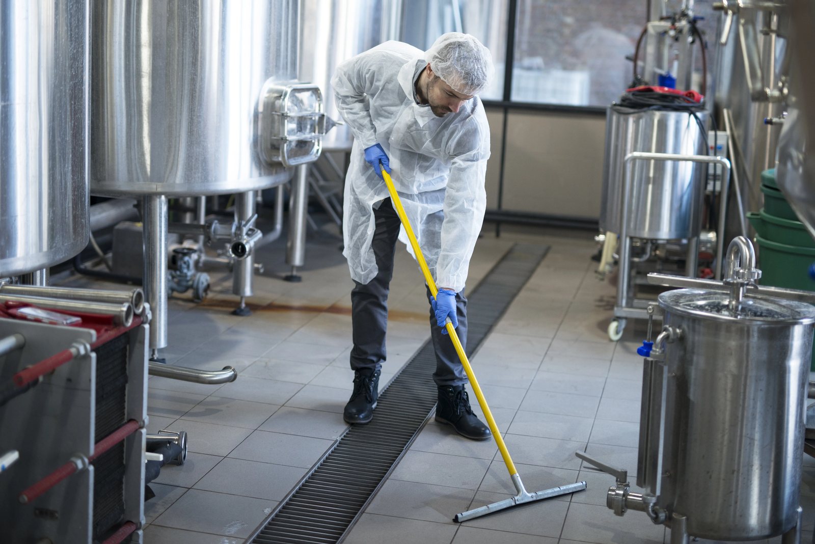 Schoonmaker reinigt de vloer van een bedrijfsruimte
