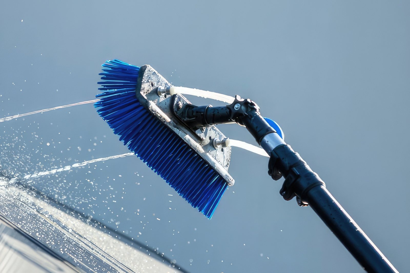 Een raam wordt gewassen met een borstel