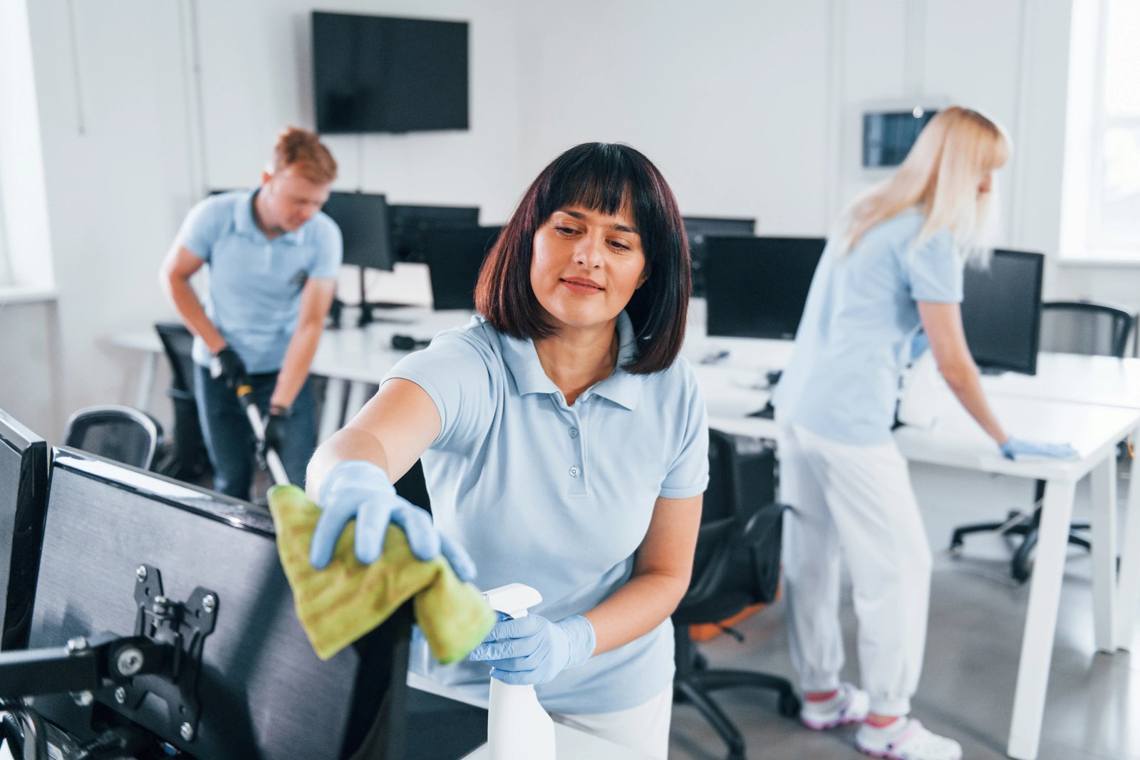 Schoonmaakteam aan de slag tussen de bureaus