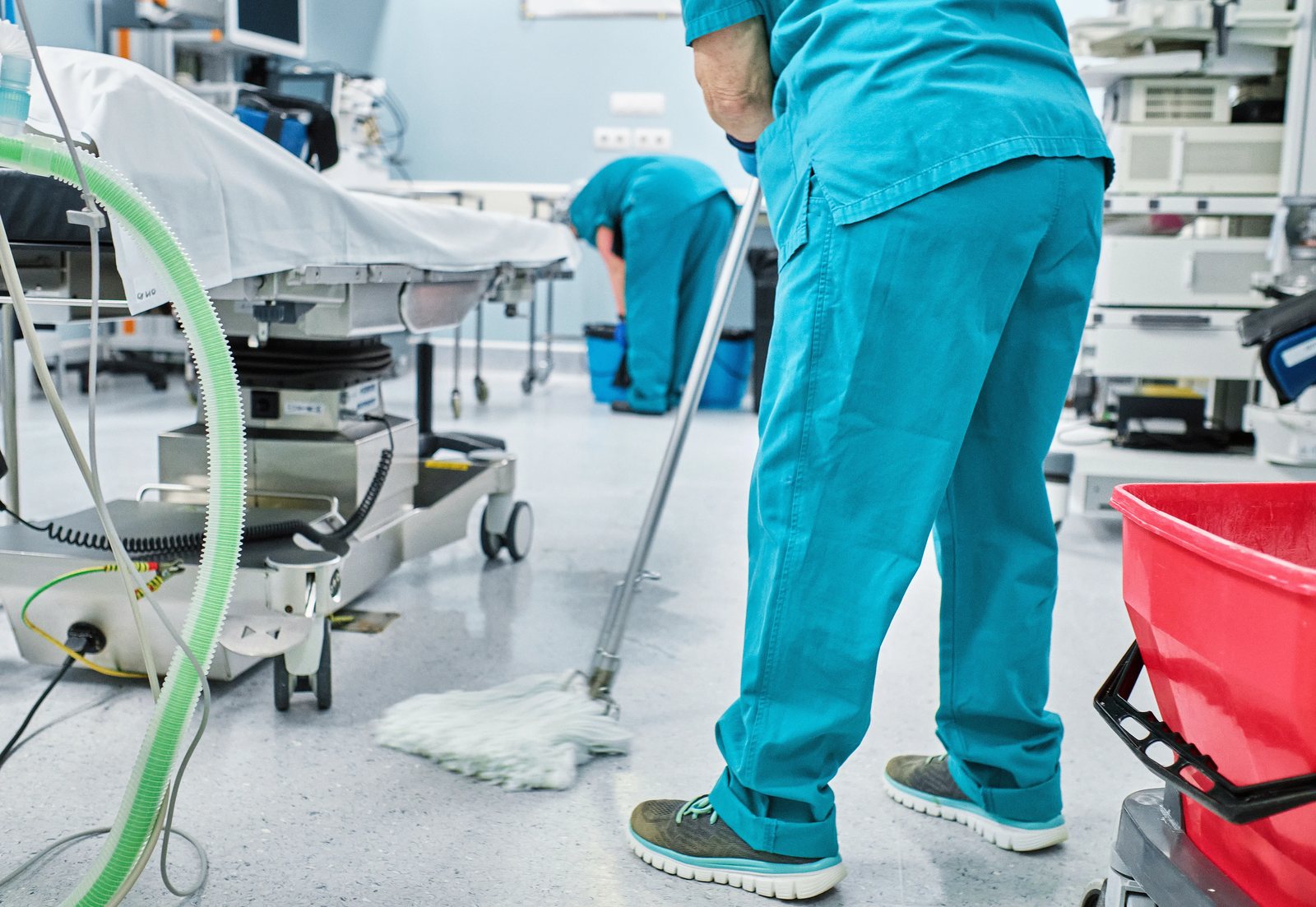 Schoonmaker reinigt de vloer van een praktijkruimte